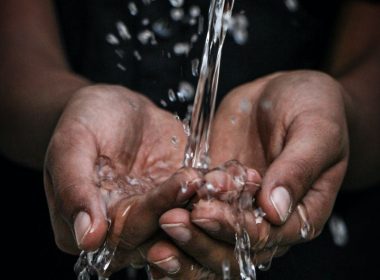 pouring water on person's hands