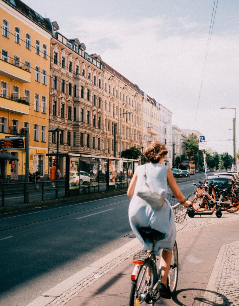 woman riding bicycle near concrete building