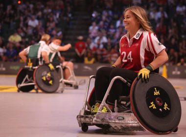 focus photo of woman in red and white polo shirt with black pants in ice wheelchair