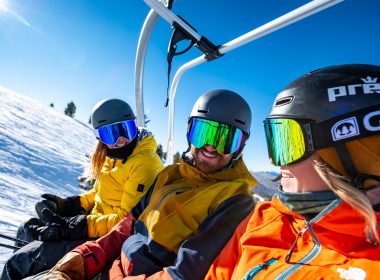 2 person in yellow jacket wearing helmet riding on cable car during daytime
