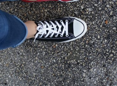 person in blue denim jeans and black and white converse all star high top sneakers