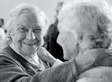 grayscale photo of woman in sweater smiling