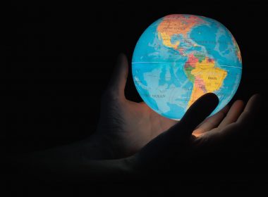 blue and brown globe on persons hand