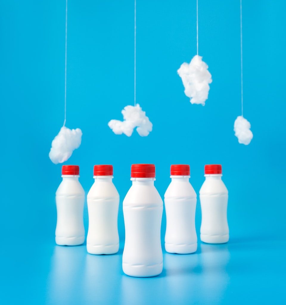 five white plastic bottles on blue surface