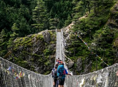 people walking on grey rope bridge during daytime