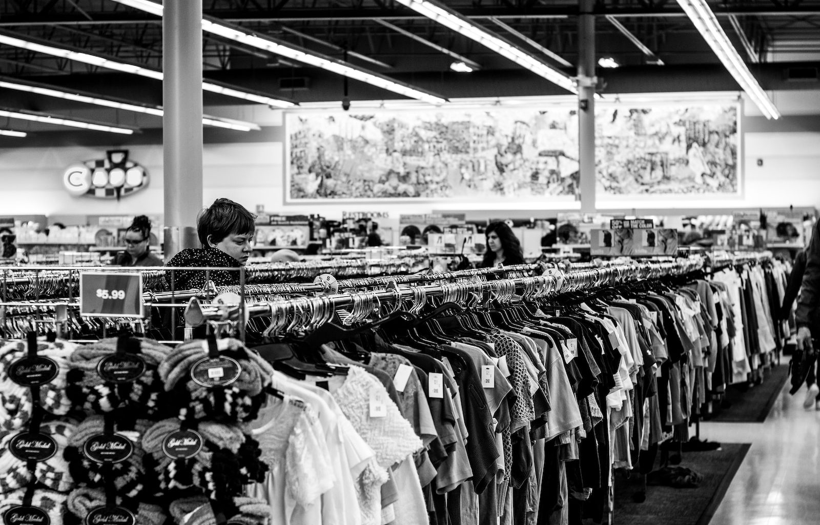 grayscale photography of people inside a clothing shop