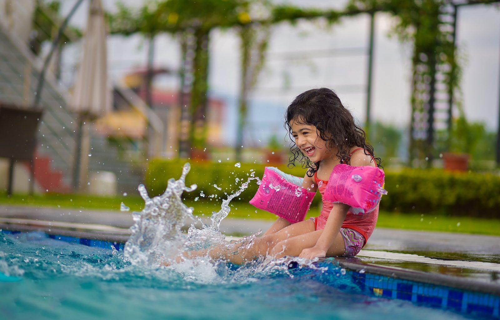 girl in pink shirt on swimming pool during daytime