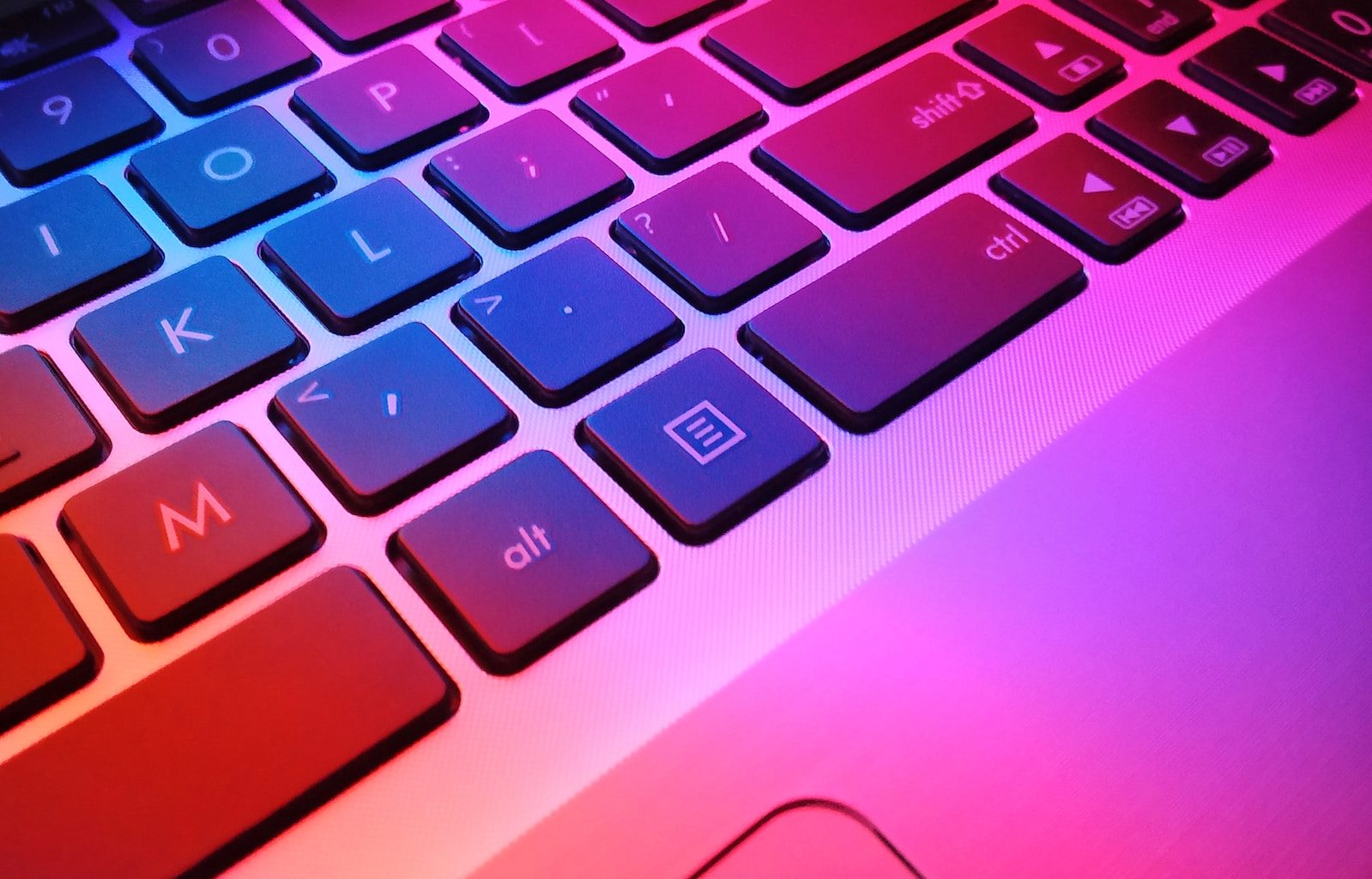 a close up of a laptop keyboard with red and blue keys