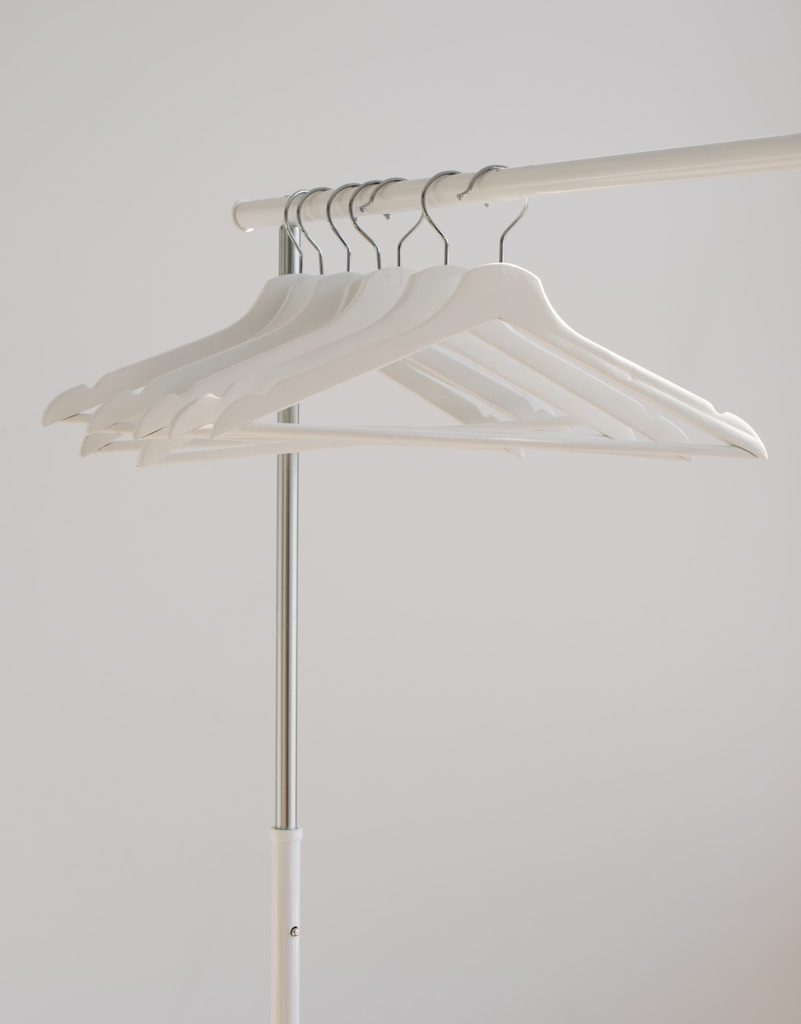 white clothes hangers hanging on rack