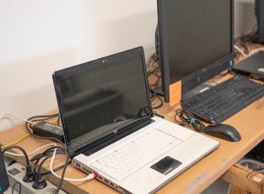 a desk with two laptops and a keyboard on it