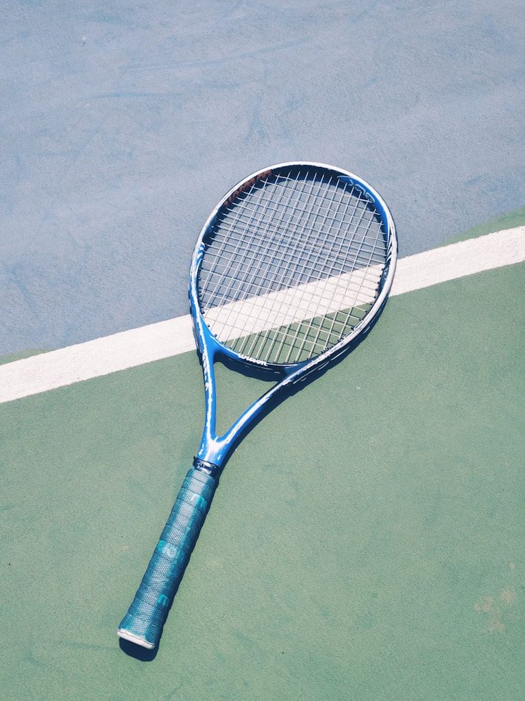 blue tennis racket on green surface