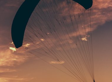 silhouette of man in parachute at golden hour
