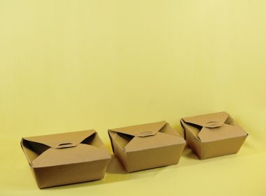three brown boxes sitting on top of a yellow surface