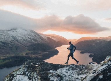 a man running up the side of a snow covered mountain