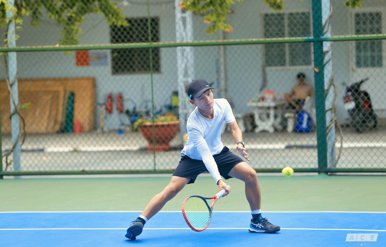 a young man holding a tennis racquet on a tennis court