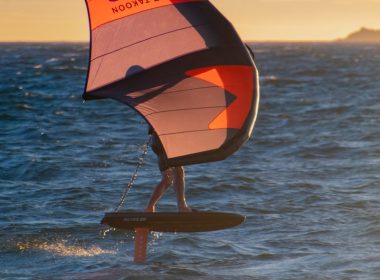 a person on a surfboard holding a sail