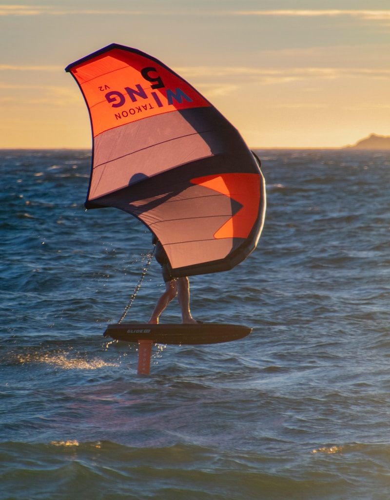 a person on a surfboard holding a sail
