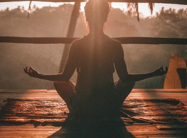woman doing yoga meditation on brown parquet flooring