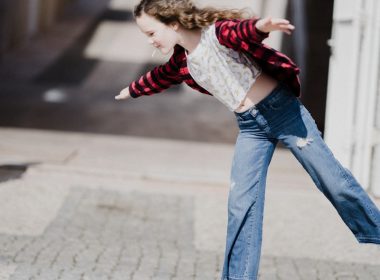girl balancing on top of concrete stand
