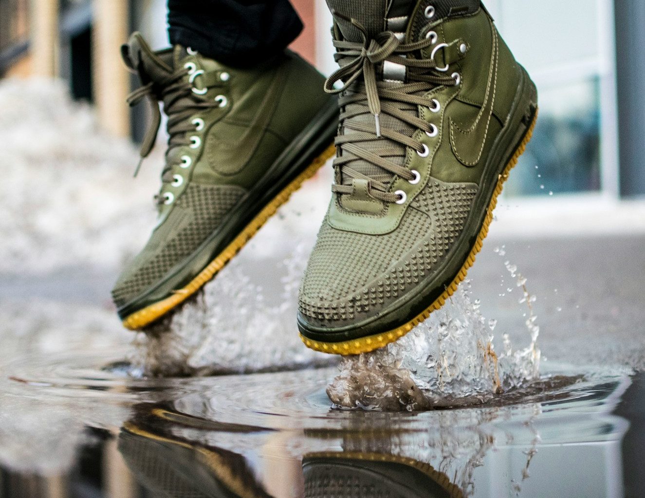 person wearing green Nike sneakers jumping on water