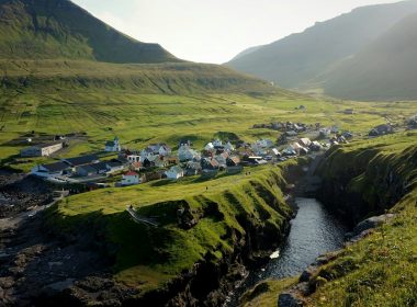 houses near the body of water under blue sky during daytime