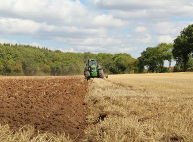 green tractor farming in field