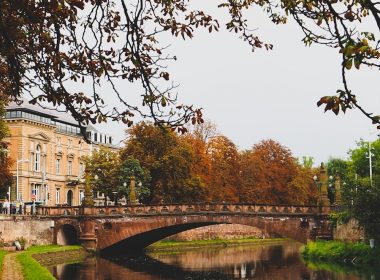a bridge over a body of water with a building in the background