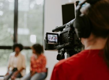man in red shirt holding black video camera