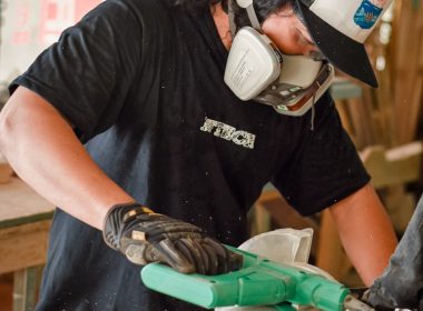 man in black crew neck t-shirt holding green and gray power tool