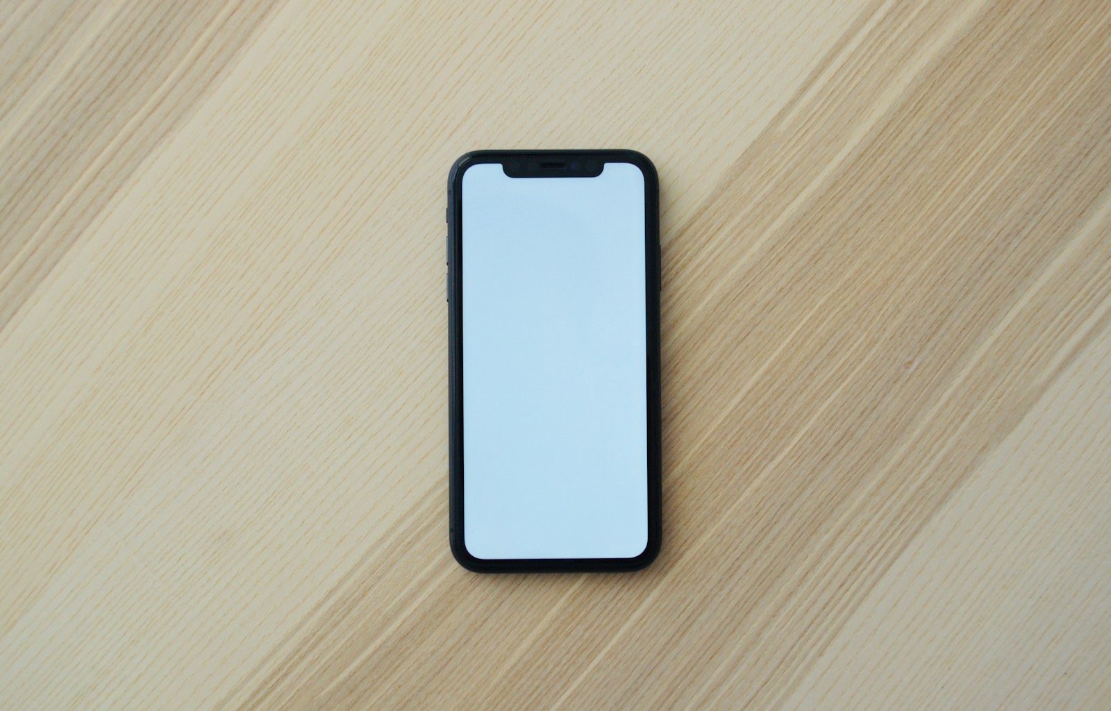 white smartphone on brown wooden table