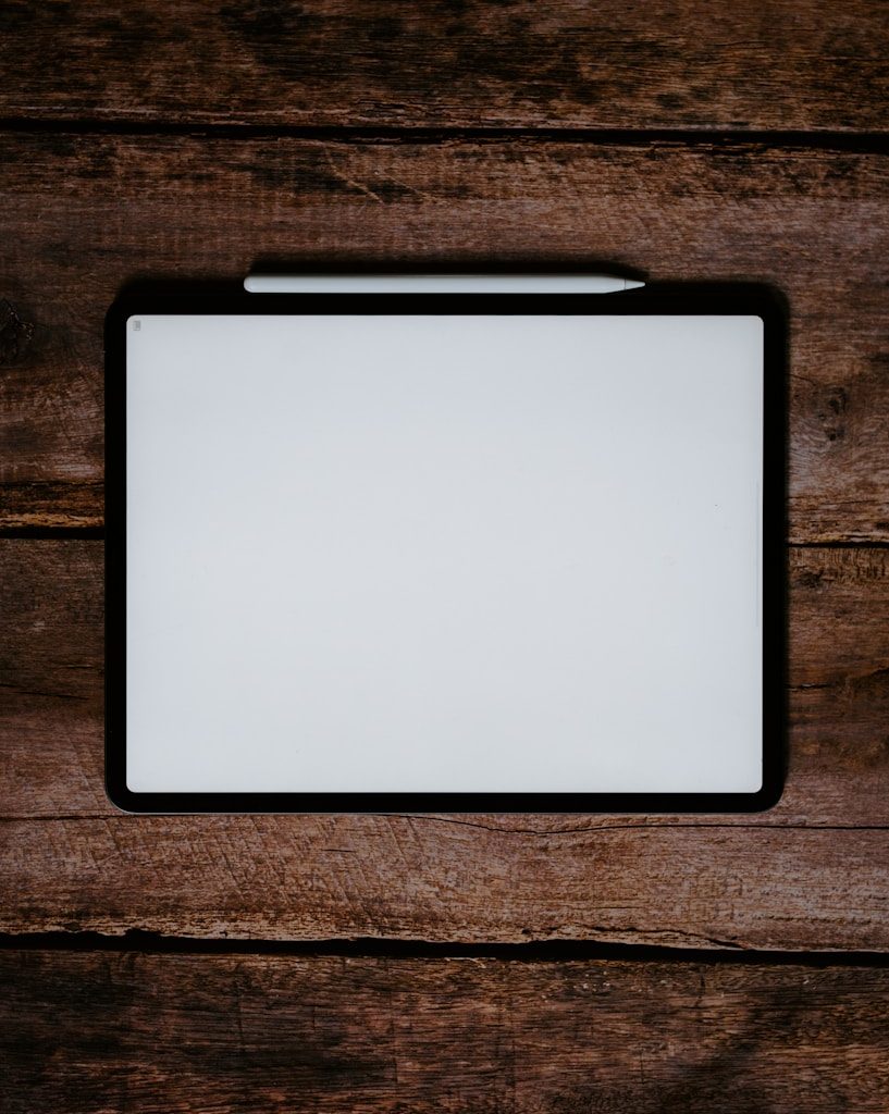 white and black tablet computer on brown wooden table