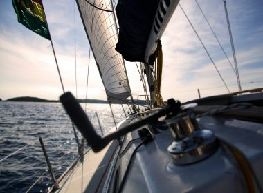 Reel on sailboat with sails sailing on water with horizon in the background