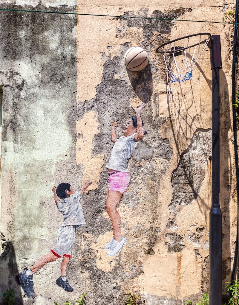 2 boys playing basketball during daytime