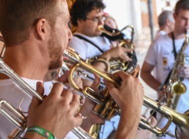 male band playing brass wind instrument outdoors