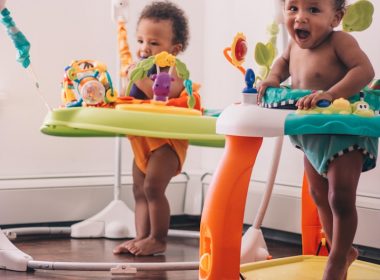 2 children playing on green and blue plastic slide