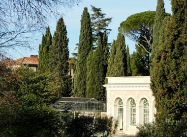 a white building surrounded by trees and bushes