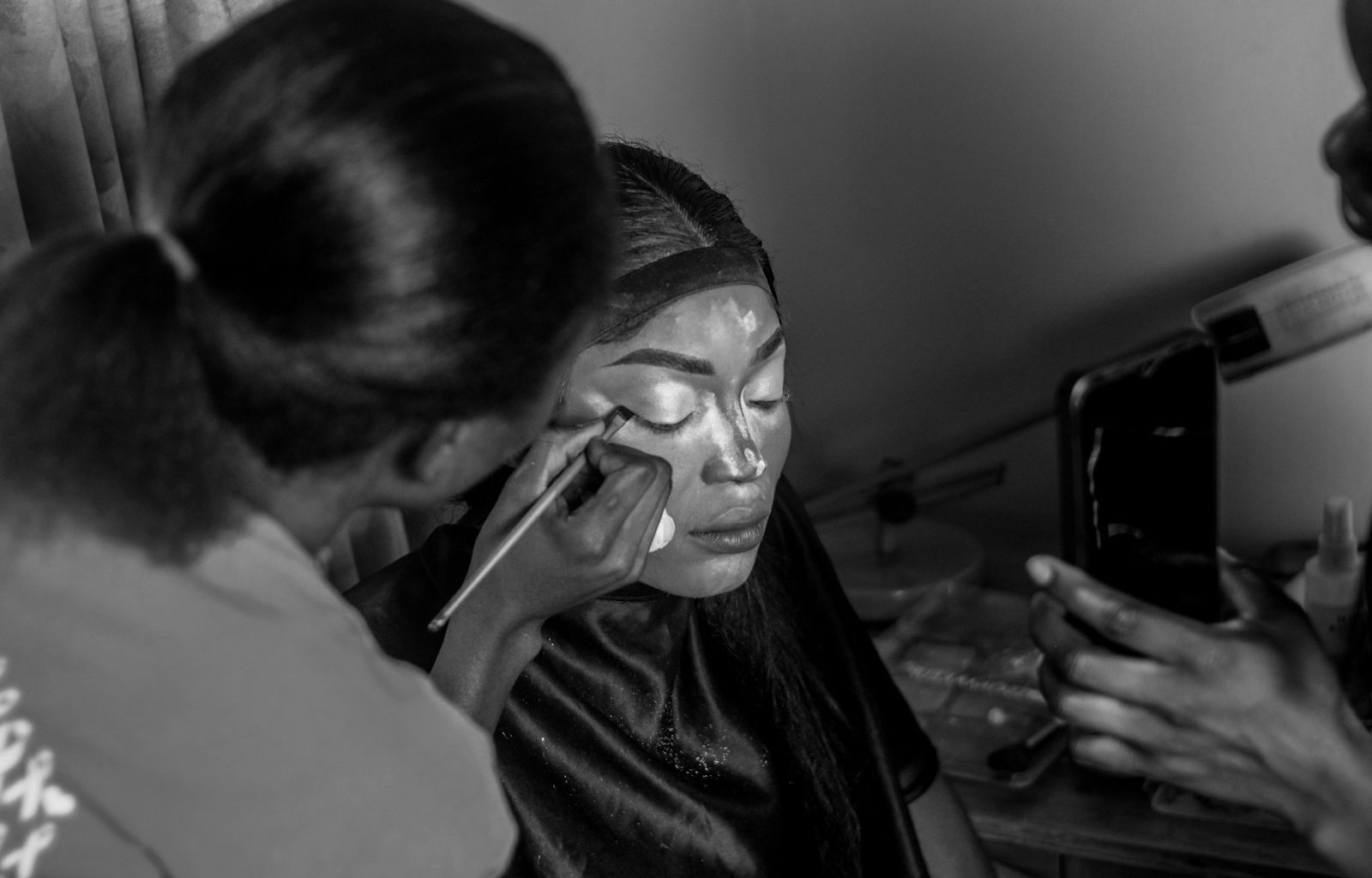 a black and white photo of a woman using a cell phone