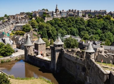 A walled medieval town sits atop a hill.