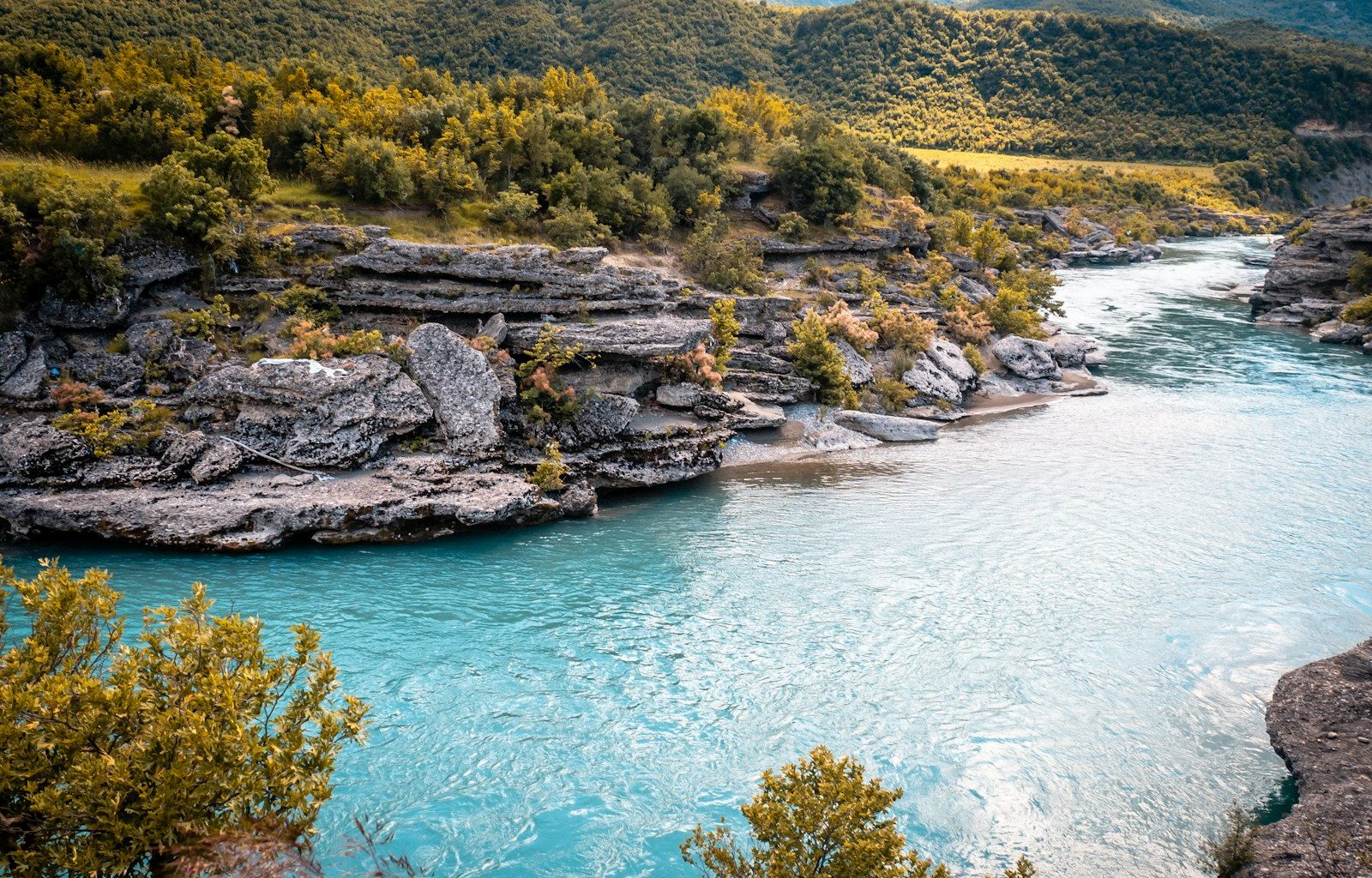A turquoise river flows through beautiful mountains.