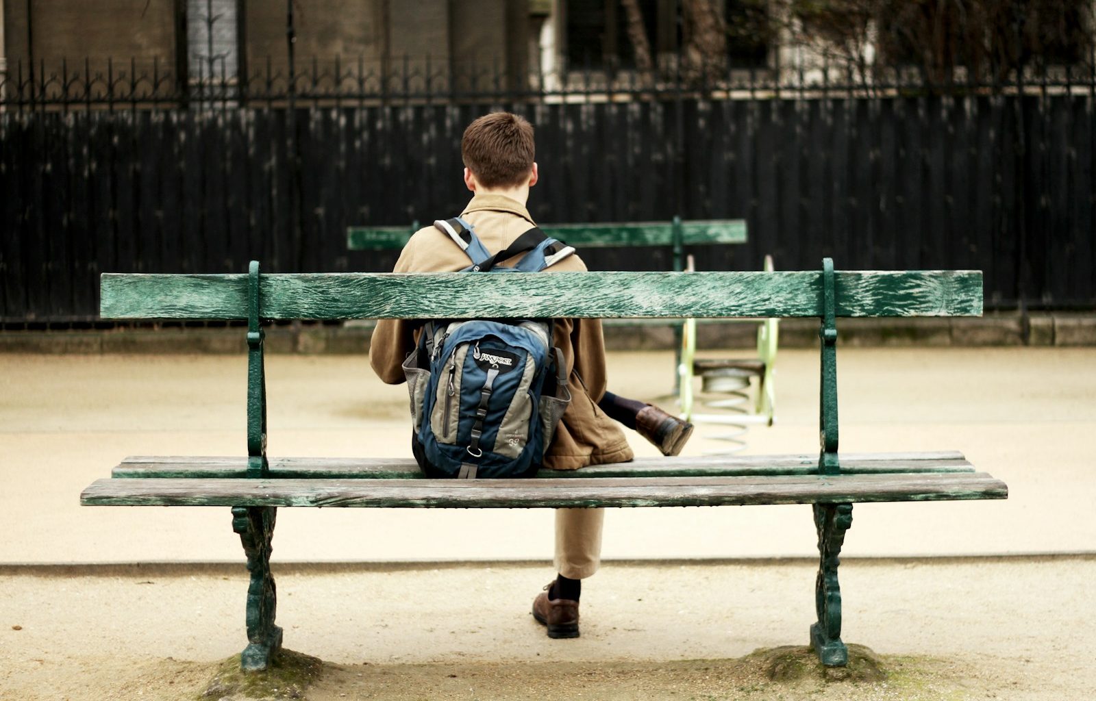 man in brown shirt sitting on bench