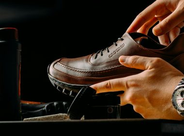 a person tying a pair of brown shoes