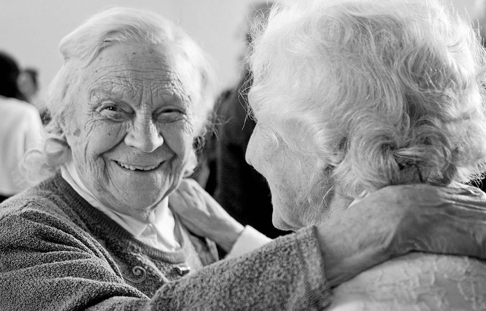 grayscale photo of woman in sweater smiling