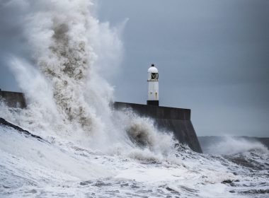 big waves crashing on lighthouse during daytime