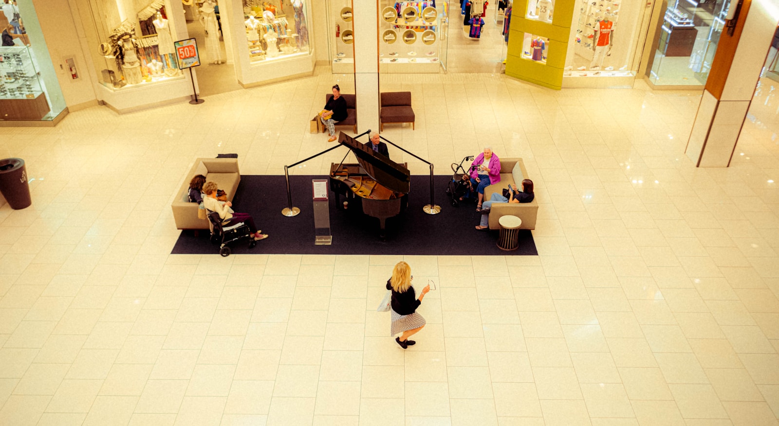a woman is walking through a mall with a piano