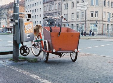 a bike with a trailer attached to it parked on the side of a street