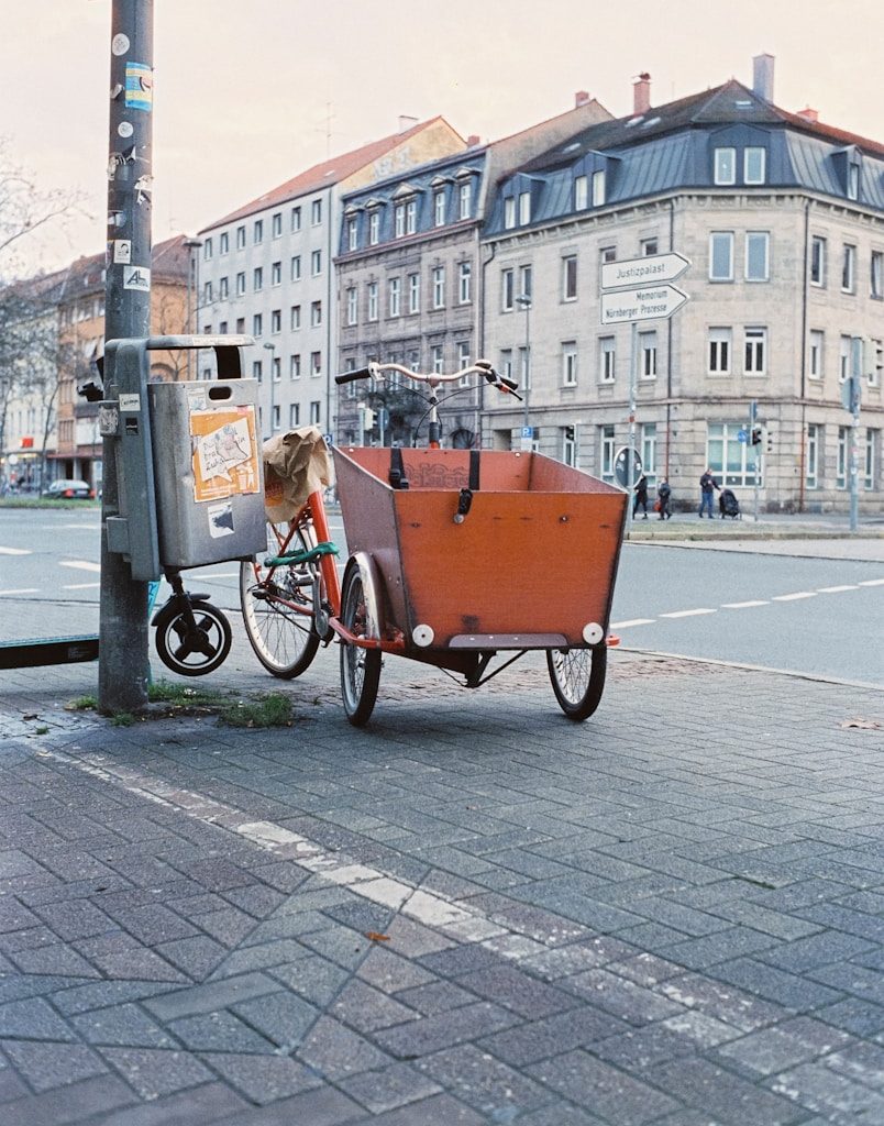 a bike with a trailer attached to it parked on the side of a street