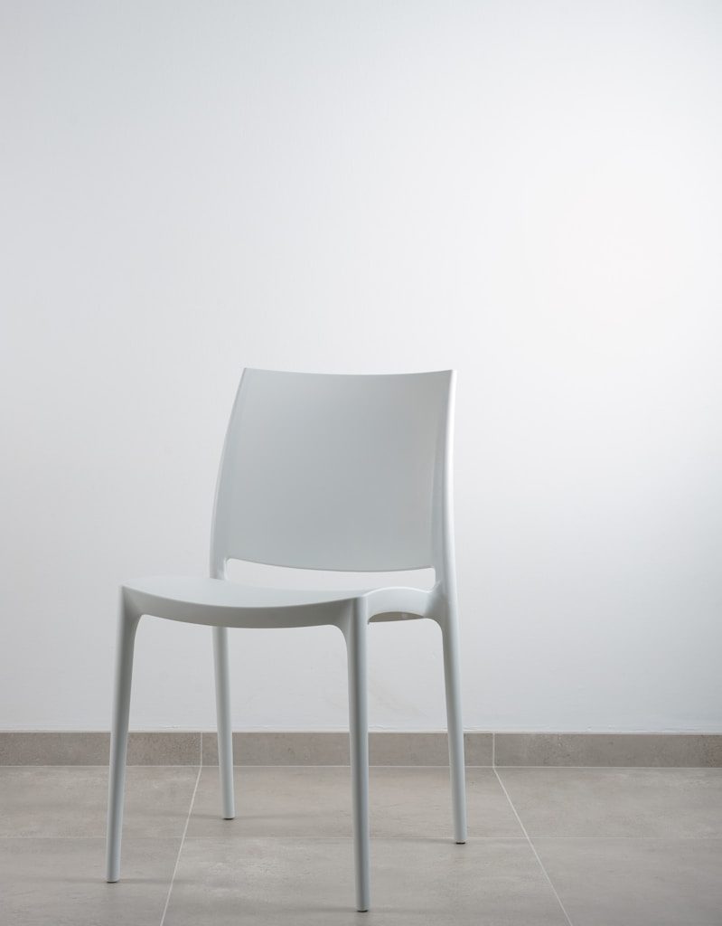 white armless chair near white wall