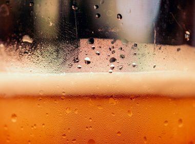 a close up of a glass of beer with drops of water