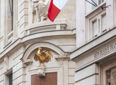a building with a flag and a statue on top of it