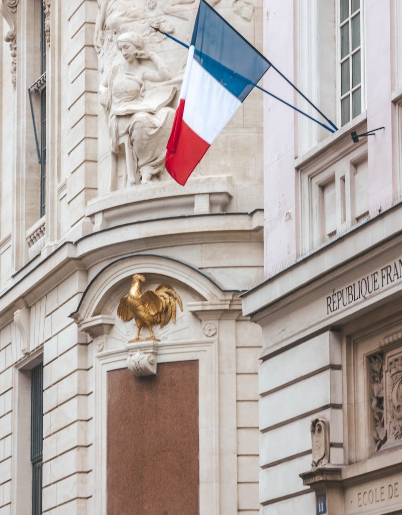 a building with a flag and a statue on top of it